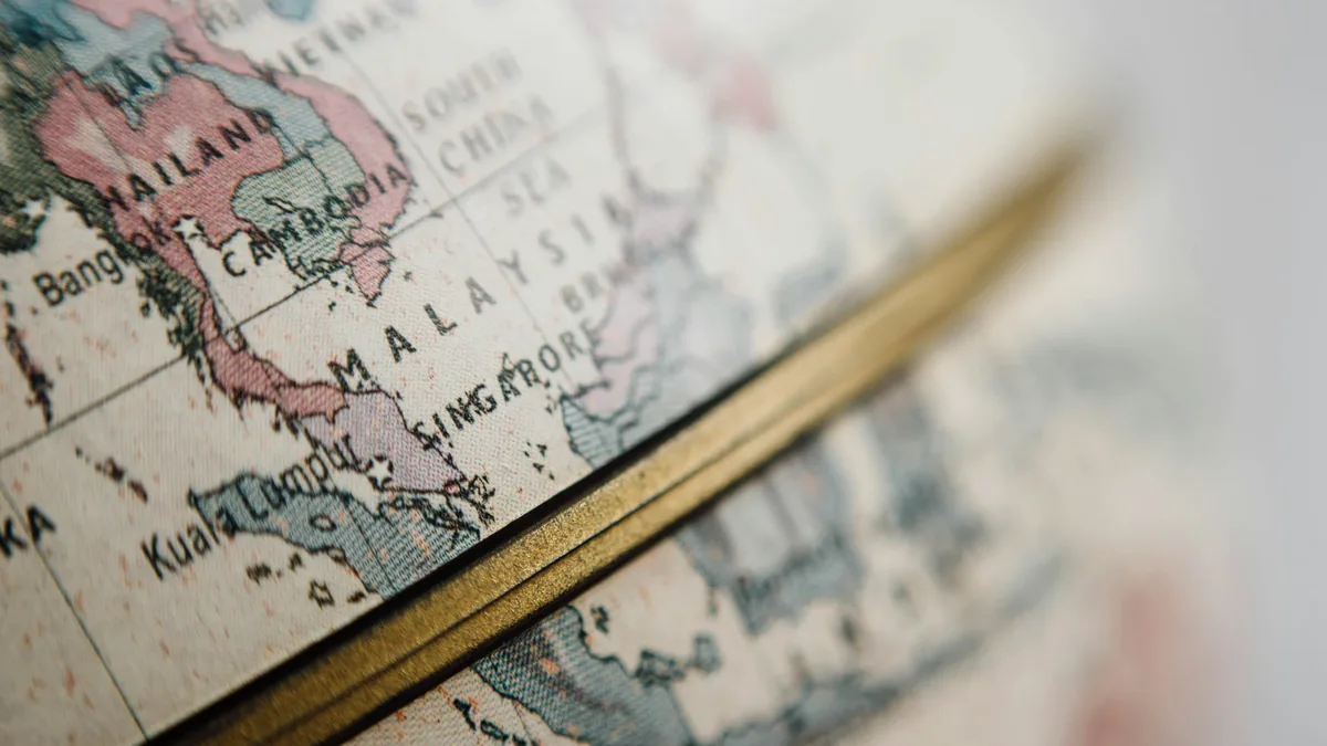 A close-up view of a globe, with the Southeast Asian region visible, including Malaysia, Singapore, and parts of Thailand, Cambodia, and Vie